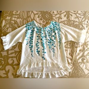 Cute top with ruffled sleeves and blue dot detailing on front.  Size L.